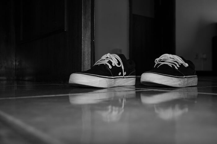 Black canvas shoes left on tiled floor near doorway, illustrating something totally normal in your country that shocks Americans.