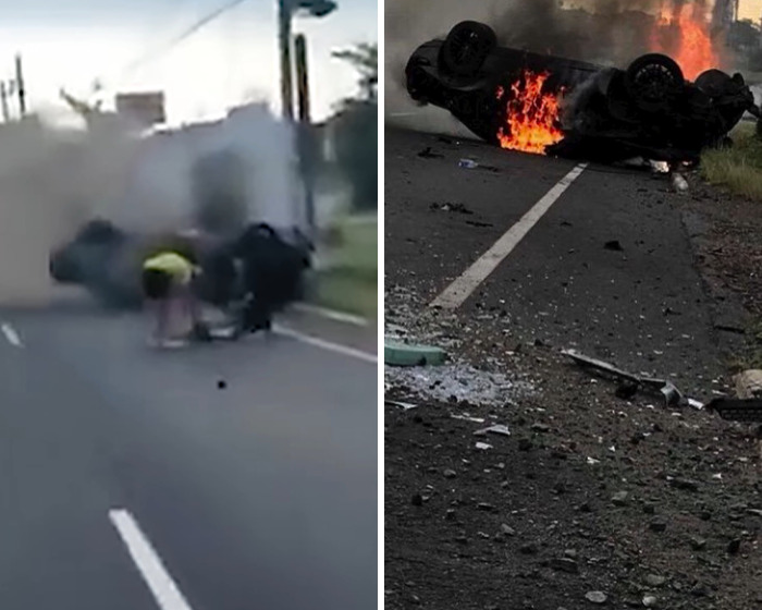 Car flipped and burning on road after crash with people assisting at the scene of the accident. Car flipped and burning on road after crash with people assisting at the scene of the accident.