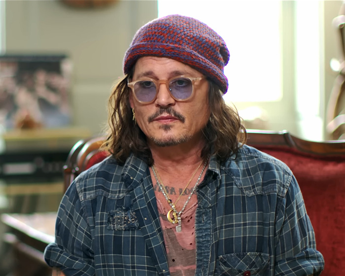 Johnny Depp wearing a plaid shirt and beanie, speaking about people who did him dirty during Amber Heard trial.