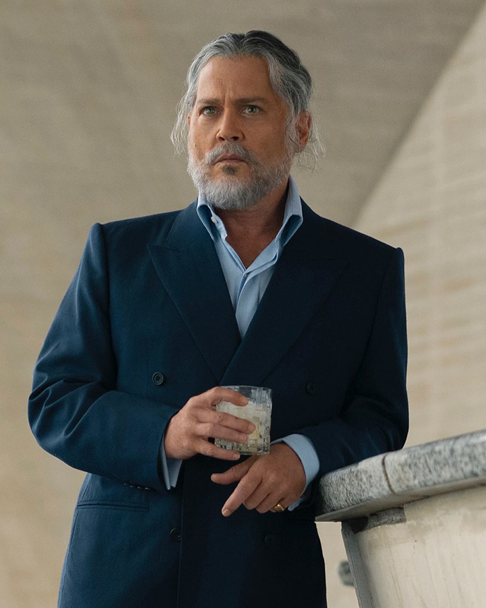 Johnny Depp with beard and suit holding a glass during Amber Heard trial revealing people who did him dirty.