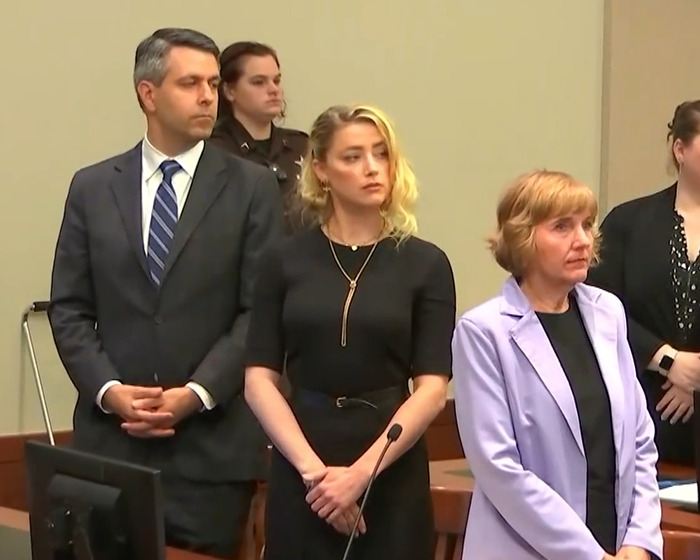 Jurors and lawyers in courtroom during Johnny Depp trial, showing serious expressions and attentive posture.
