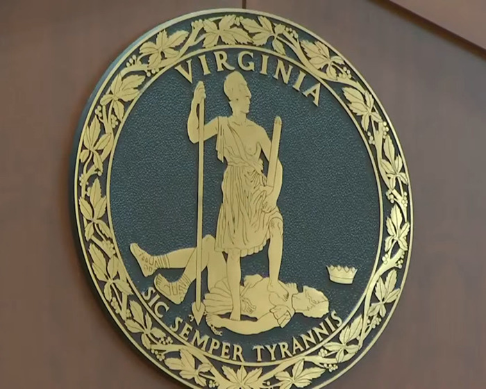 Virginia state seal mounted on courtroom wall during Johnny Depp trial juror revealing courtroom secrets.