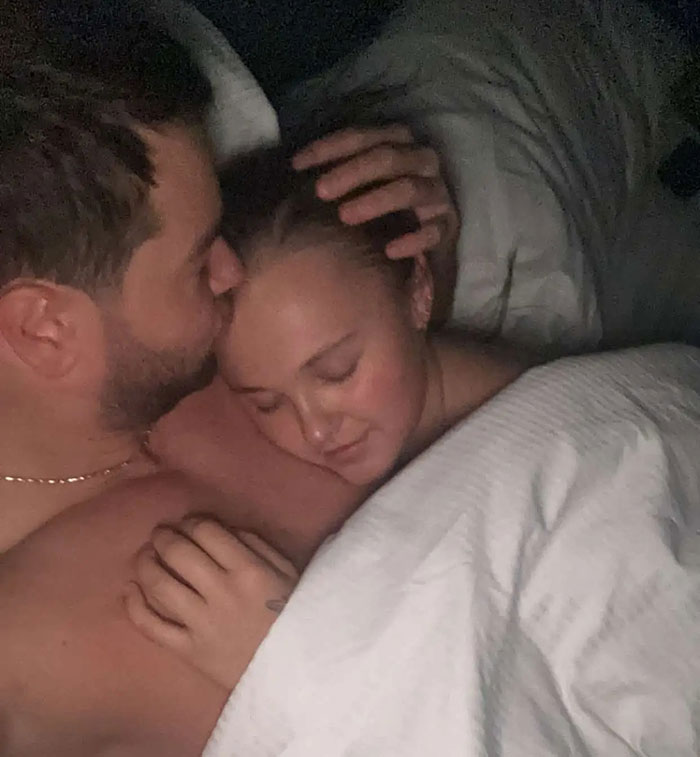 A tender moment of a couple cuddling in bed, reflecting JoJo Siwa hits back after Miley Cyrus Pride joke backlash. A tender moment of a couple cuddling in bed, reflecting JoJo Siwa hits back after Miley Cyrus Pride joke backlash.