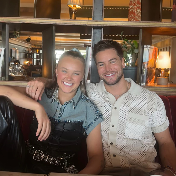 JoJo Siwa and partner smiling in casual outfits, sparking conversation about orientation and Pride Month backlash.