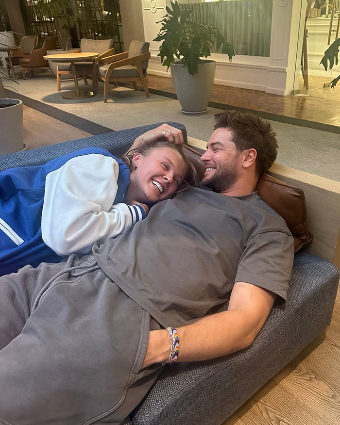 Couple relaxing together indoors sharing a joyful moment on the first day of Pride Month orientation discussion.