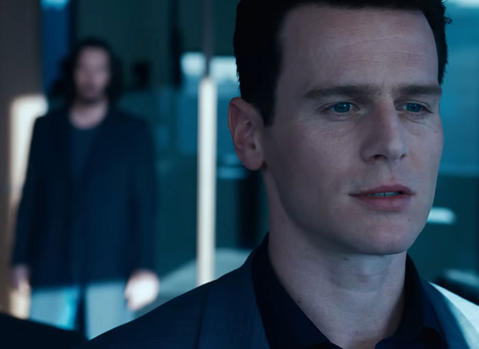 Actor Jonathan Groff in sharp focus with Keanu Reeves blurred in the background during a tense moment at the 2025 Tony Awards.