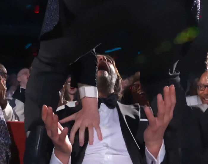 Keanu Reeves reacting as Jonathan Groff straddles him live at the 2025 Tony Awards, sparking a lively audience reaction.