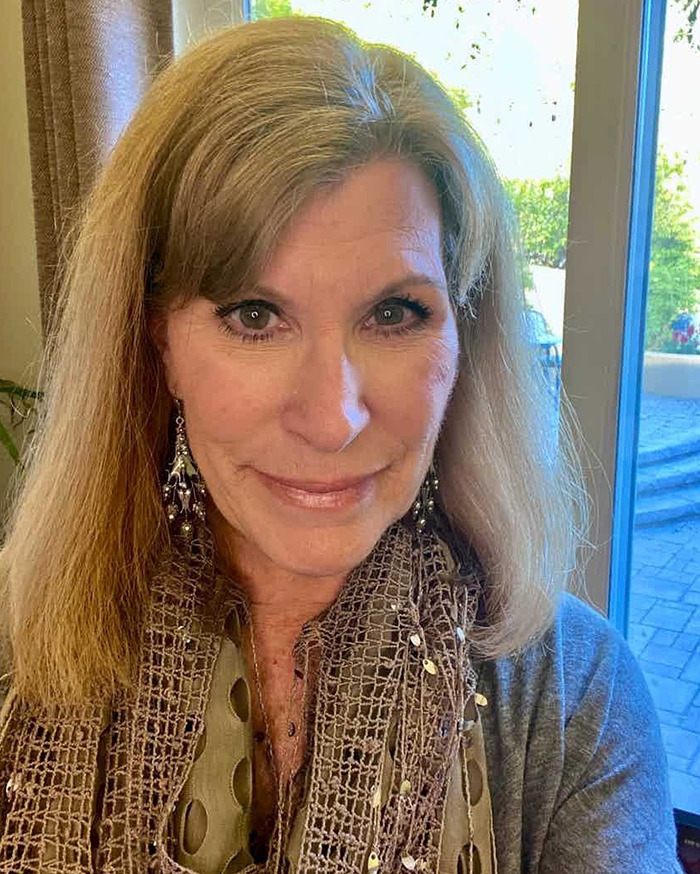 70s TV actress with blonde hair wearing a patterned scarf and earrings, smiling indoors near a window. 70s TV actress with blonde hair wearing a patterned scarf and earrings, smiling indoors near a window.