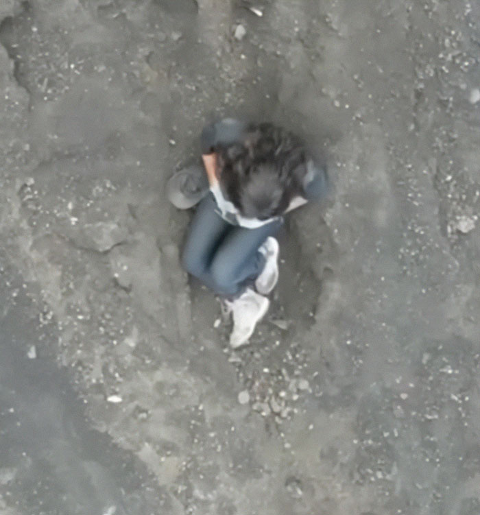 Person sitting distressed on rocky ground during volcano tours amid disturbing claims and outrage over abandoned tourist's passing Person sitting distressed on rocky ground during volcano tours amid disturbing claims and outrage over abandoned tourist's passing