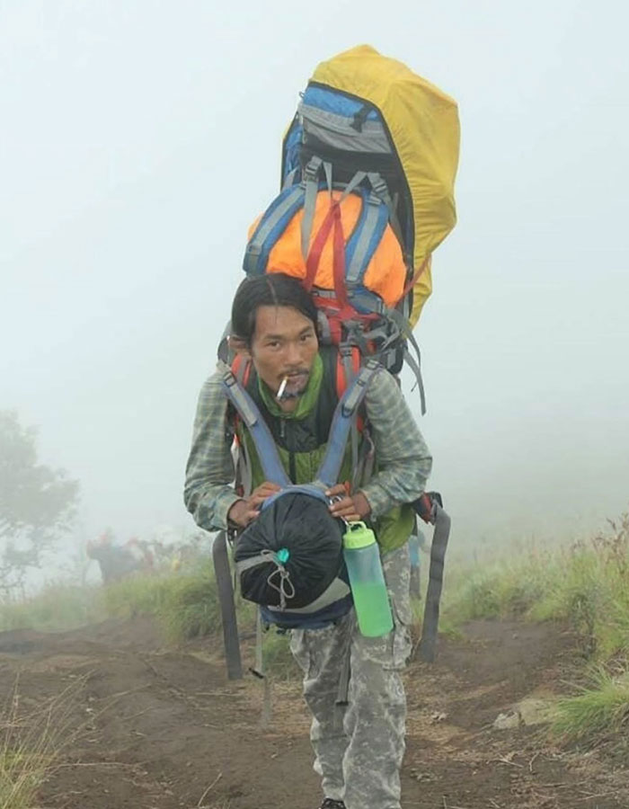 Guide accused of abandoning tourist carries heavy backpack hiking on foggy active volcano trail. Guide accused of abandoning tourist carries heavy backpack hiking on foggy active volcano trail.