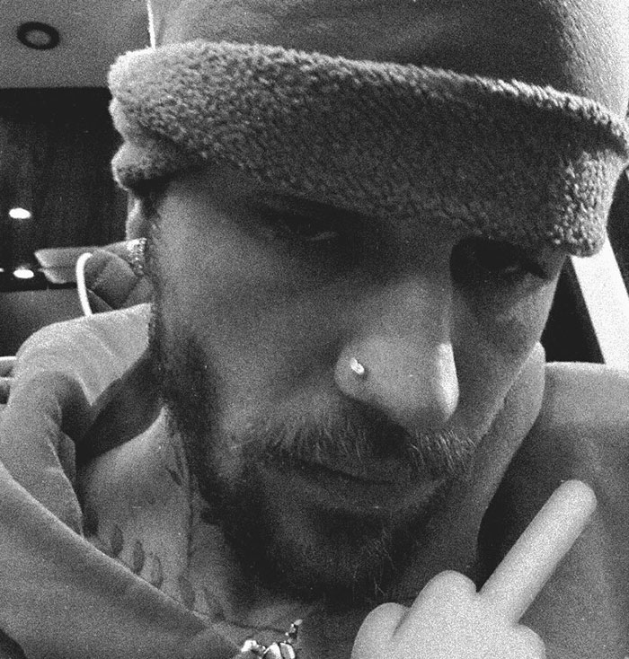 Close-up black and white portrait showing a man wearing a hat and hoodie, related to Hailey Bieber Father's Day revenge on Justin.