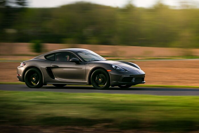 A sleek sports car speeding on a rural road, capturing a moment of fast driving and motion blur effects.