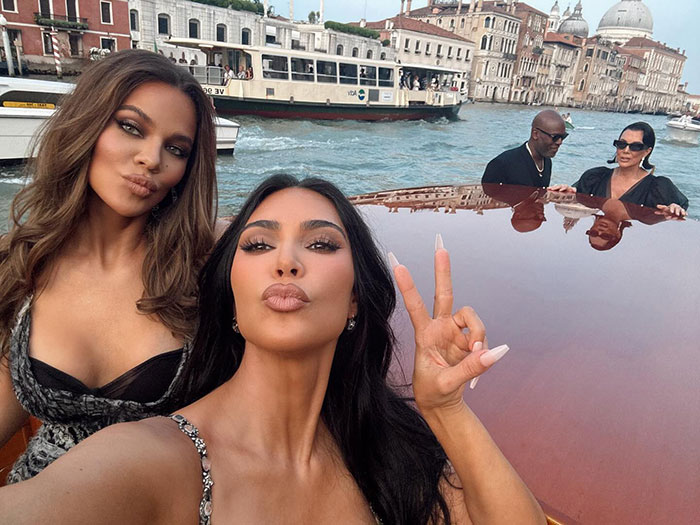 Kim Kardashian and friends taking a selfie on a boat, related to guests crying at Jeff Bezos wedding ceremony.