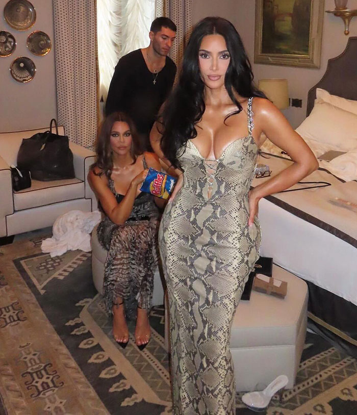 Kim Kardashian posing in a snakeskin dress with guests reacting after Jeff Bezos' wedding ceremony event