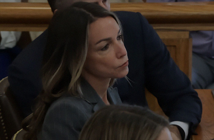 Karen Read attending trial proceedings, appearing contemplative and serious in a courtroom setting during acquittal case.