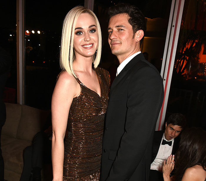 Katy Perry and Orlando Bloom dressed elegantly at an event, posing closely together with smiles. Katy Perry and Orlando Bloom dressed elegantly at an event, posing closely together with smiles.
