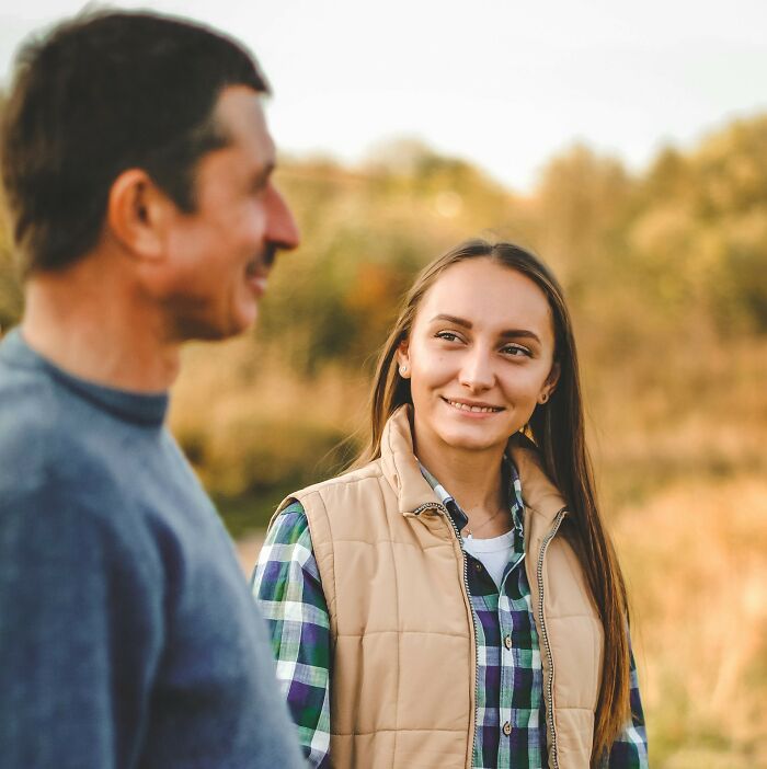 A young woman smiling at a man outdoors, reflecting on secrets people feel deeply ashamed to confess to partners.