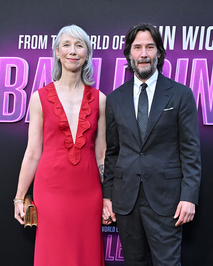 Keanu Reeves and girlfriend holding hands on red carpet sparking rumors they secretly married after appearance.