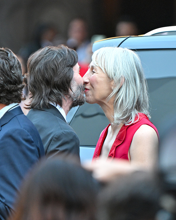 Keanu Reeves and girlfriend sharing a close moment, sparking rumors of secret marriage after red carpet appearance.