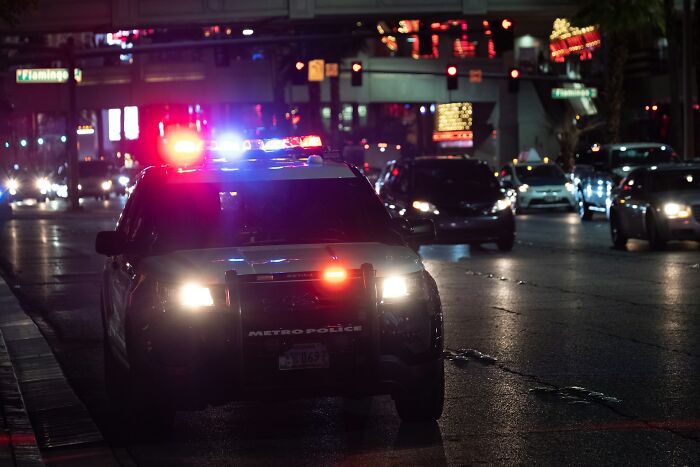 Police car with flashing lights at night on city street, illustrating creepy and scary moments from truck drivers’ lives.
