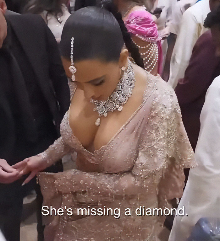 Kim Kardashian wearing intricate jewelry and a detailed pink outfit at an event, highlighting fashion and celebrity style. Kim Kardashian wearing intricate jewelry and a detailed pink outfit at an event, highlighting fashion and celebrity style.