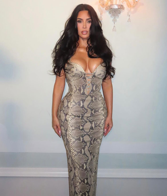 Kim Kardashian posing in a snakeskin dress, linked to claims about guests crying at Jeff Bezos wedding ceremony.