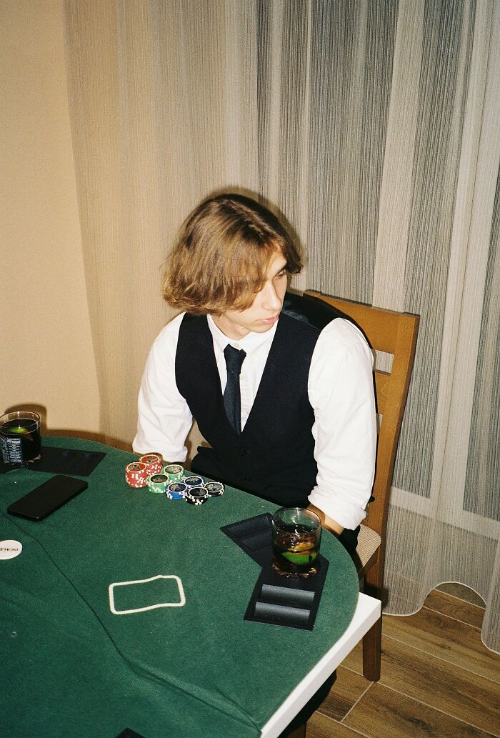 Young man at poker table looking away with a serious expression, capturing moments people realized their friend was a jerk.