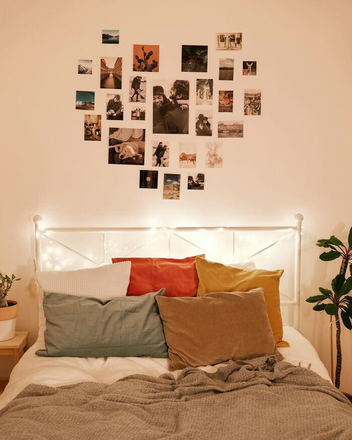 Cozy bedroom with colorful pillows, string lights, and photos on the wall illustrating moments women let their exes get away with.