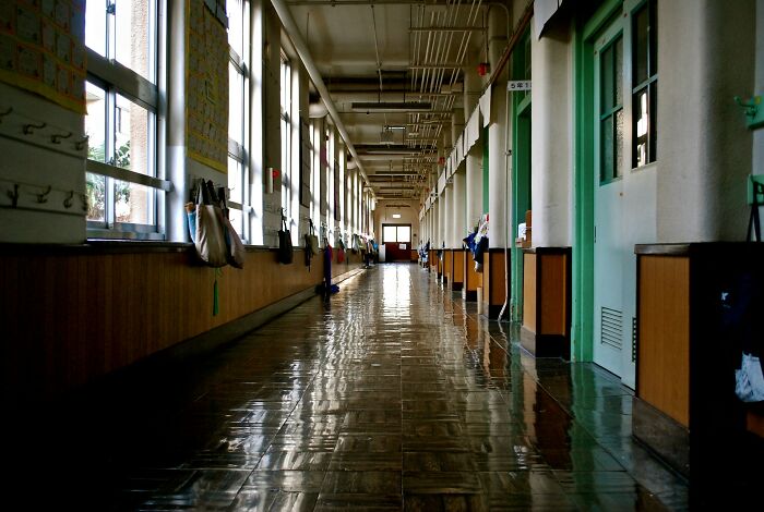 Empty school hallway with polished floors and hanging bags, illustrating awkward moments when nice guys turned creepy.
