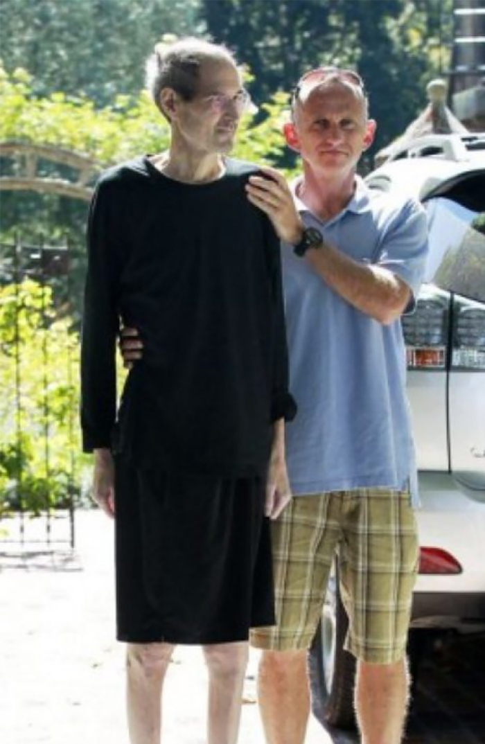 Two men outdoors by a car, one supporting the other, in a candid moment from last known photos of famous people