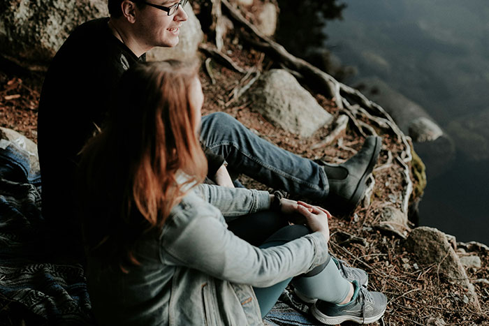 Couple sitting by a lake enjoying nature, illustrating moments that left their dates at a loss for words.