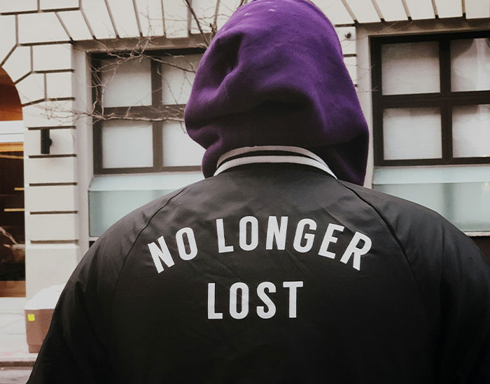 Person wearing a black jacket and purple hood facing away, symbolizing lawyers identifying cases unlikely to win.