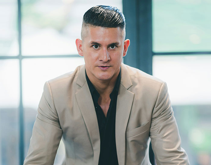 Man in beige suit in professional setting symbolizing lawyers assessing cases and legal challenges.