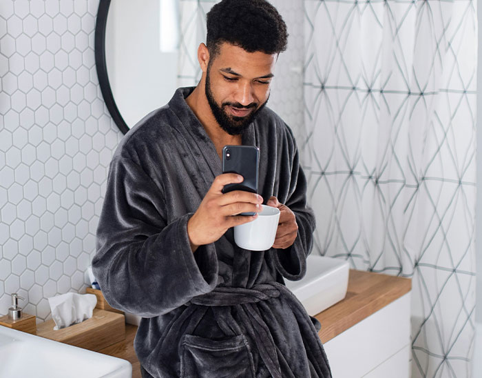 Man in a robe holding a mug and smartphone, showing lawyers immediately knew their case was unwinnable.