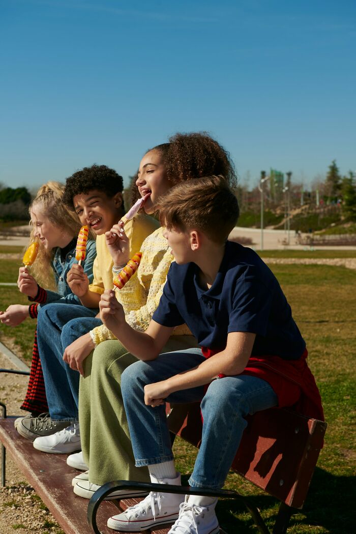 Group of children enjoying ice cream outdoors, capturing the unique childhood joys of a life not recorded by smartphones.
