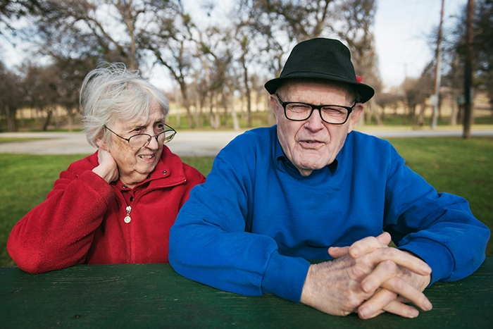 Elderly couple sitting outdoors at a table, representing parents reacting to woman dating someone 16 years older. Elderly couple sitting outdoors at a table, representing parents reacting to woman dating someone 16 years older.