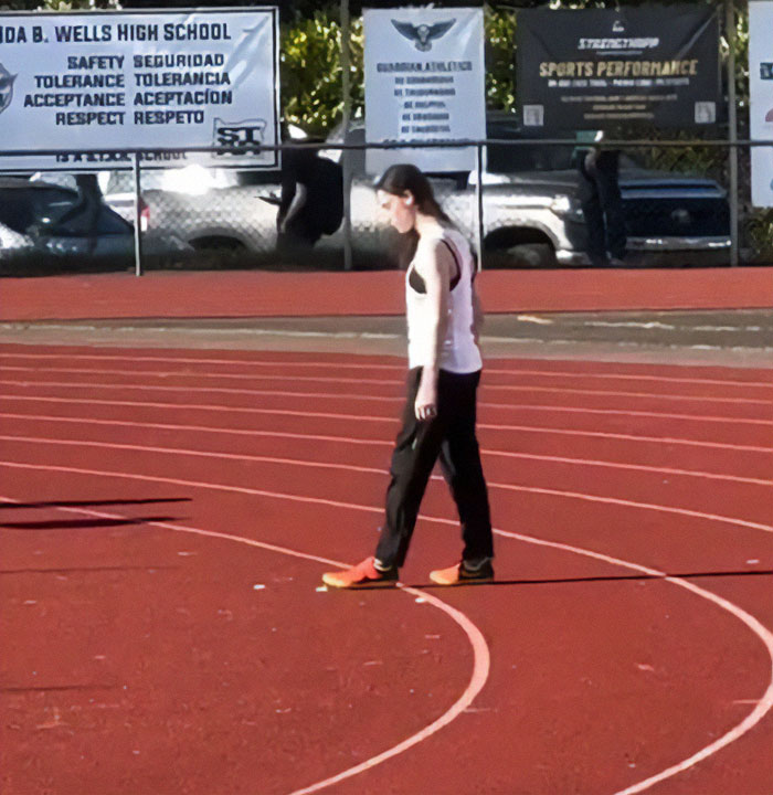 Transgender athlete standing alone on a running track after cis rivals refuse to share the podium. Transgender athlete standing alone on a running track after cis rivals refuse to share the podium.