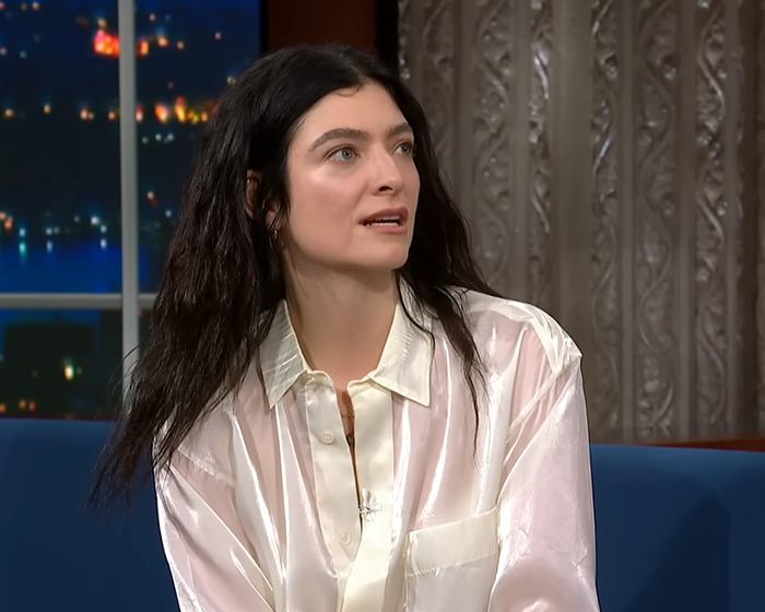 Lorde in a white satin blouse during a televised interview, discussing music and new vinyl release controversy. Lorde in a white satin blouse during a televised interview, discussing music and new vinyl release controversy.