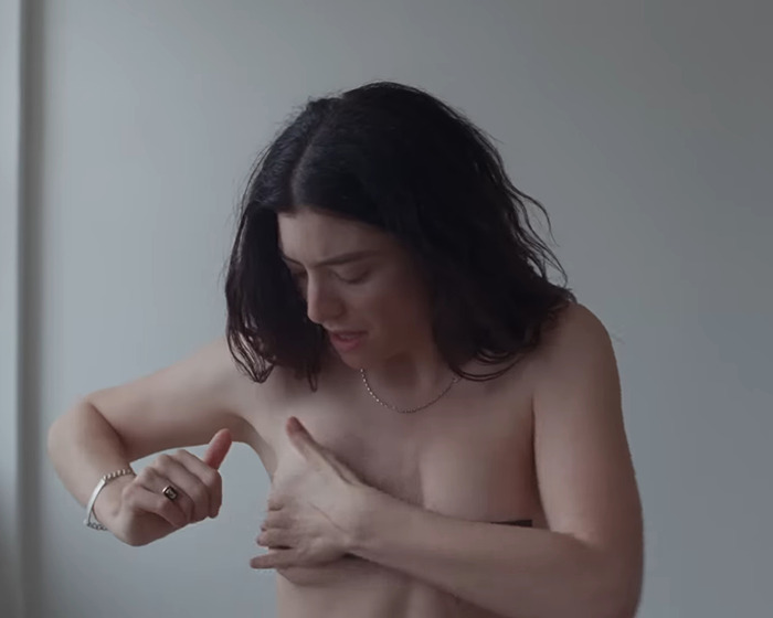 Lorde adjusting hair with bare shoulders visible, related to fans finding x-rated image in new vinyl release. Lorde adjusting hair with bare shoulders visible, related to fans finding x-rated image in new vinyl release.