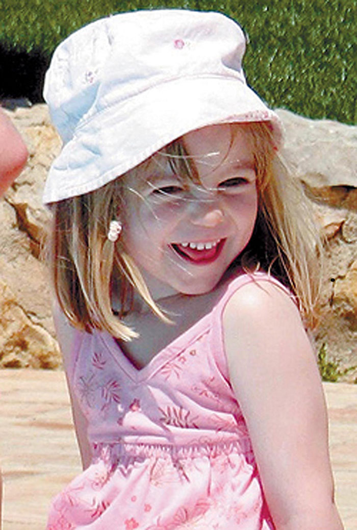 Smiling young girl wearing a white hat and pink dress outdoors related to Madeleine McCann disappearance theory.