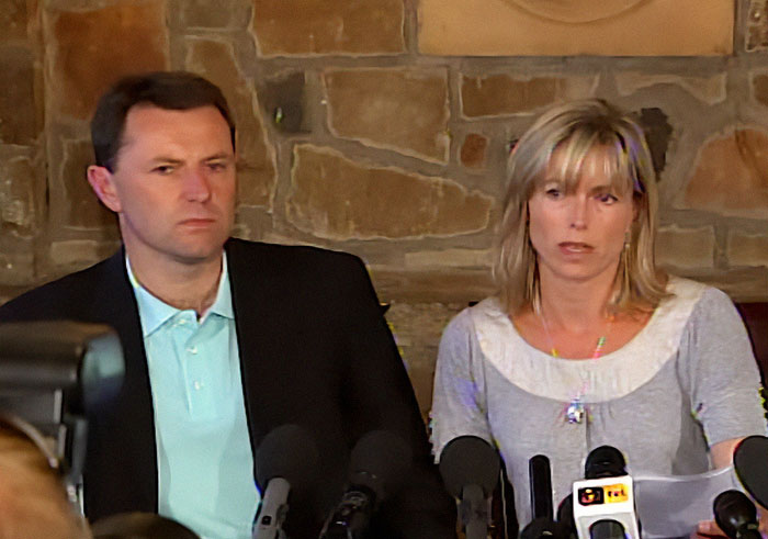 Two individuals at a press conference with microphones, related to Madeleine McCann detectives discovering buried weapons.