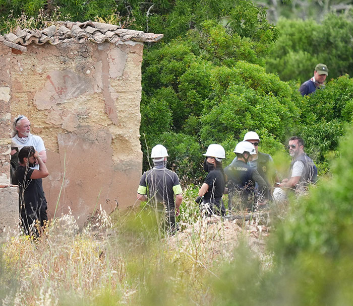 Investigators and workers wearing helmets examine a rural area linked to Madeleine McCann disappearance theory.
