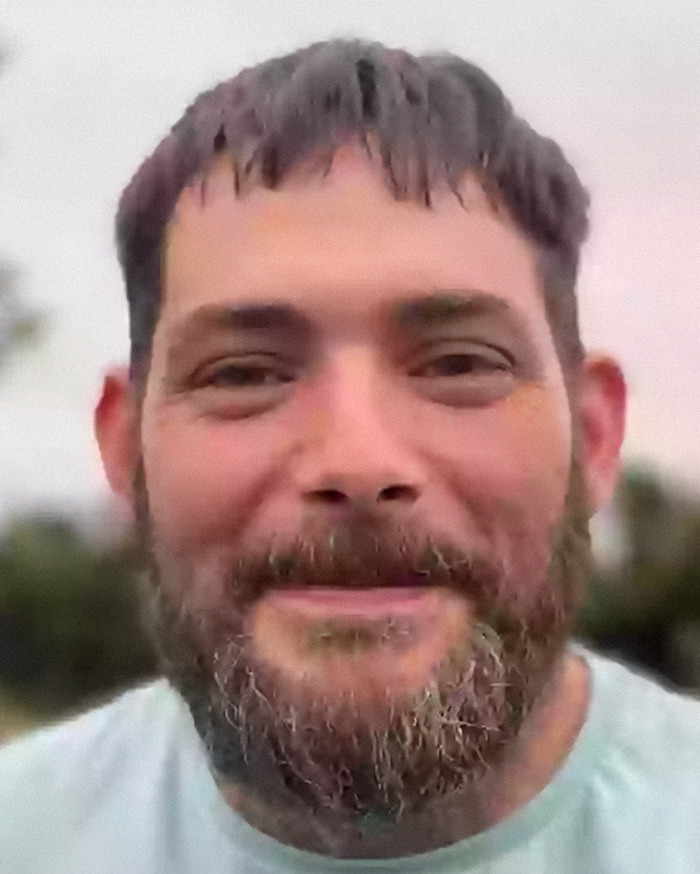 Man with beard smiling outdoors, representing man abandoned as baby in plastic bag and left in toilet reunion story.