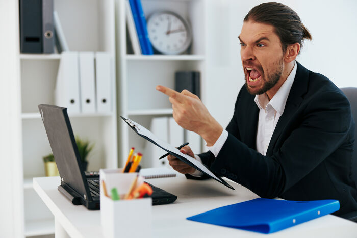 Angry man in business suit pointing finger and yelling at laptop, illustrating awful people in certain professions. - 6