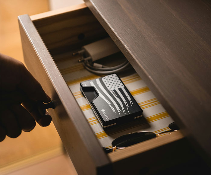 Man opening drawer with wallet inside, symbolizing tracking down and turning in a childhood friend who committed robbery.