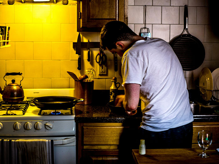 Man cooking in a cozy kitchen, evoking moments when men made women think he stands out in romantic gestures.