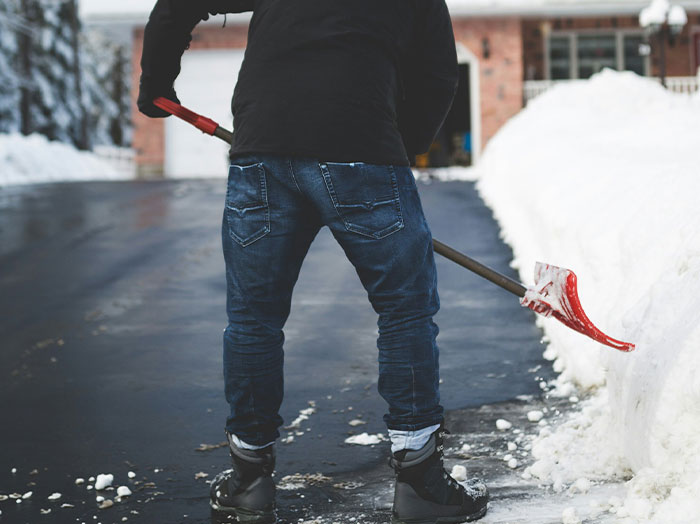 Man standing out by shoveling snow on driveway in winter, capturing moments men made women think wow he stands out