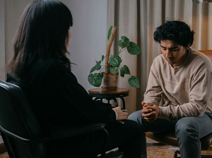 Man sitting thoughtfully during a conversation with a woman in a cozy room, showing moments men made women think wow stands out