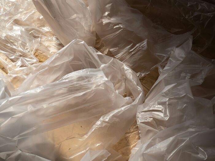 Crumpled translucent plastic sheets overlapping in dim light, symbolizing the shortcomings of being big in Japan.
