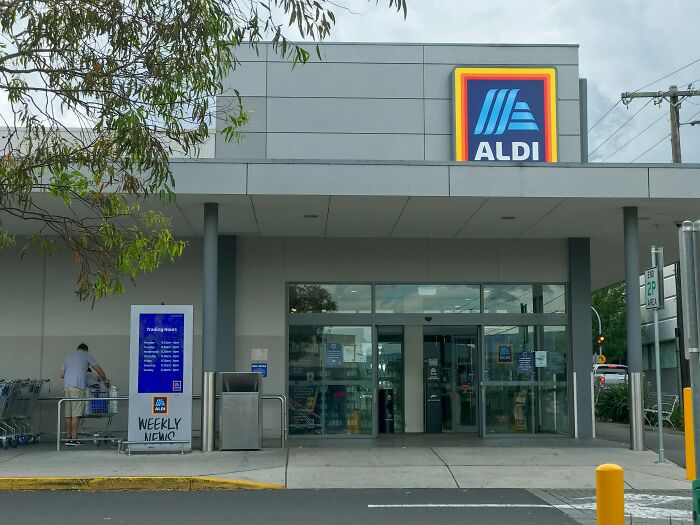 Aldi store entrance with shopping carts outside, illustrating poor people habits in everyday shopping routines.